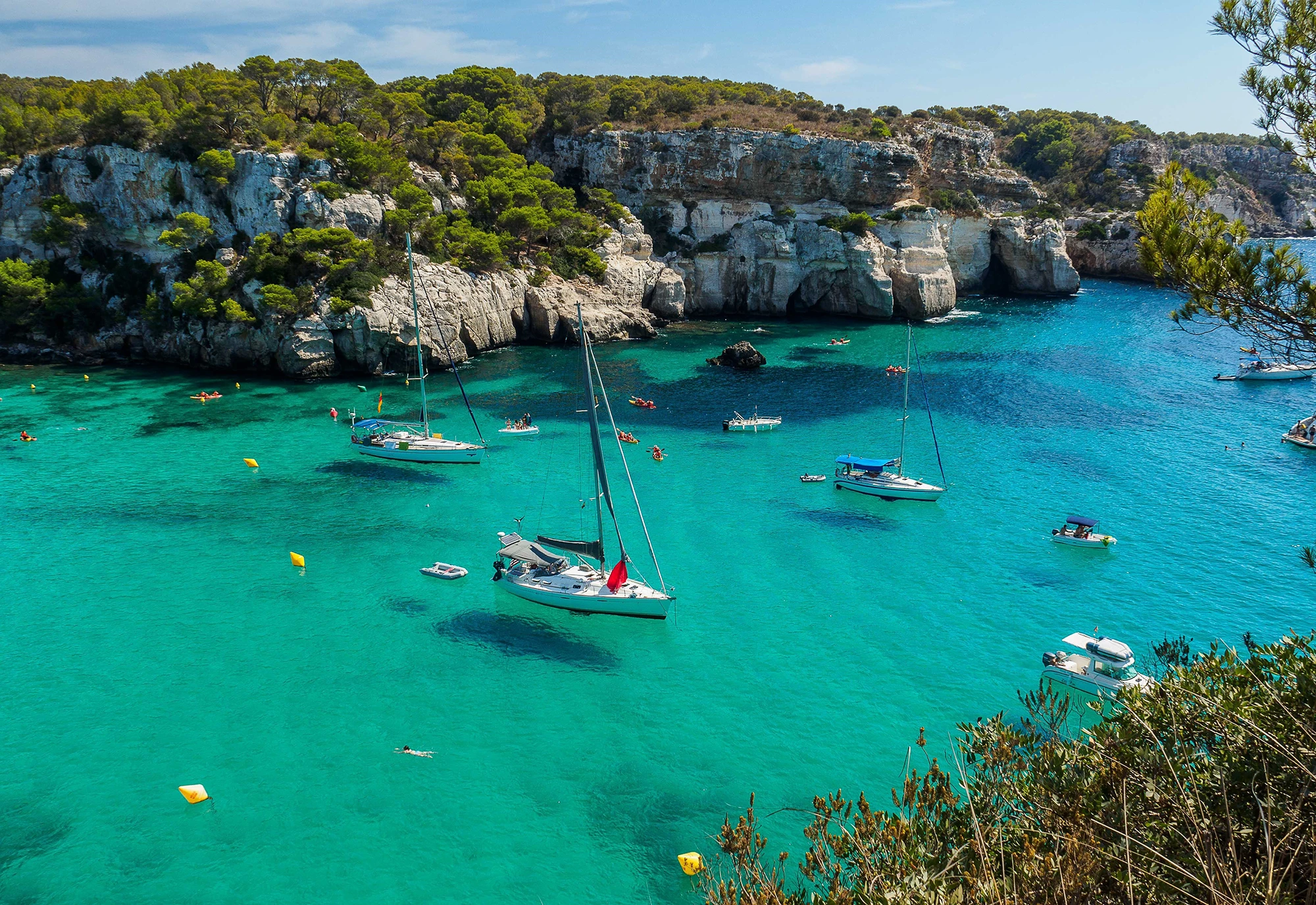 Cala de matressa in Menorca with crystal clear water and sailing boats
