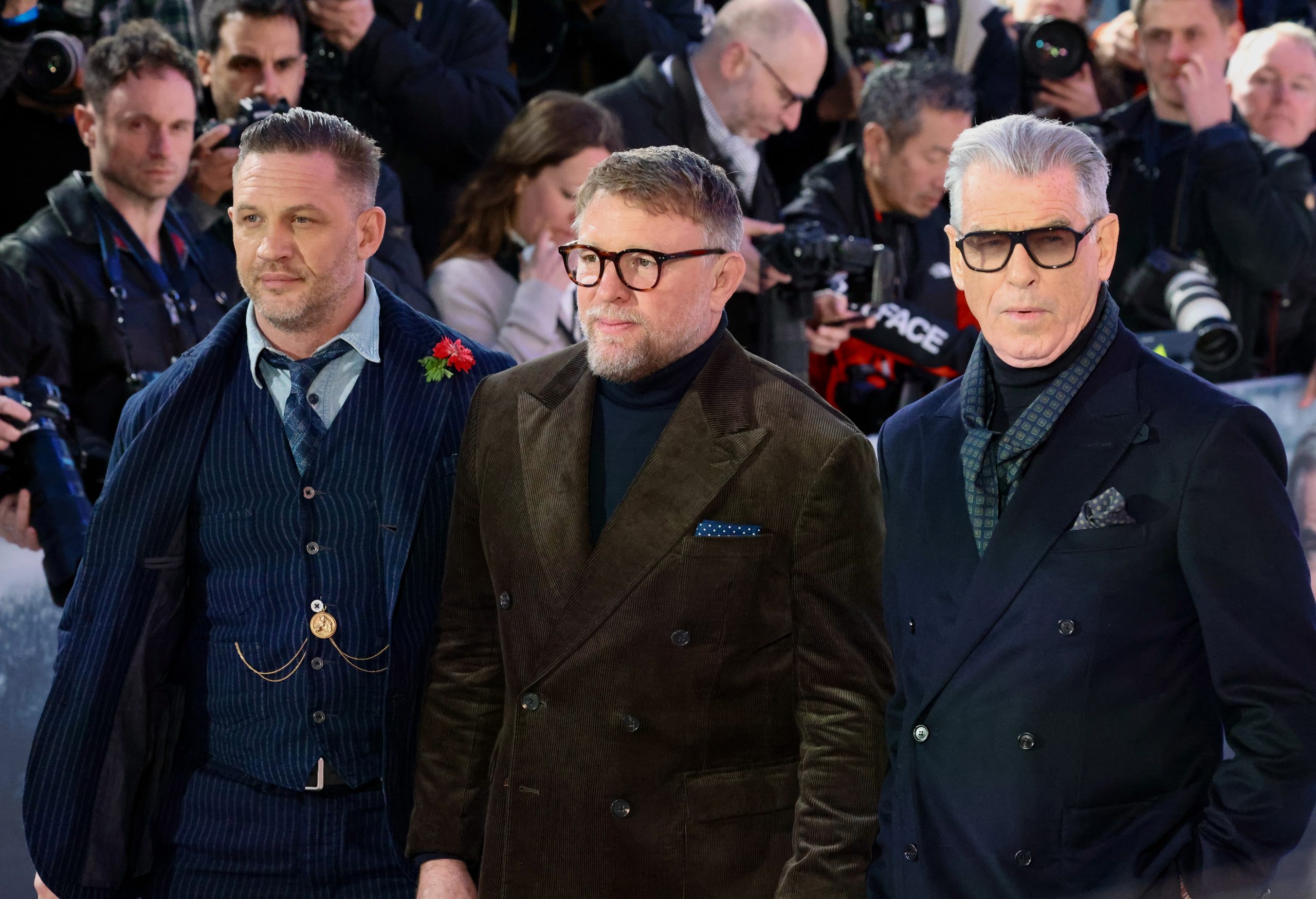 Alt Text: Tom Hardy Guy Ritchie and Pierce Brosnan at the MobLand London premiere