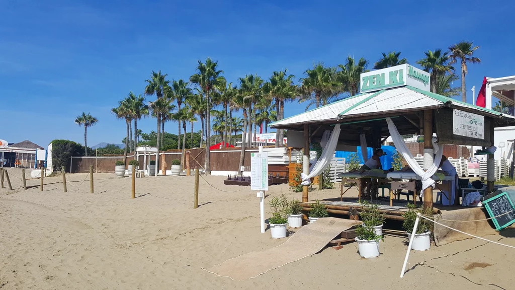 Elviria beach outside Nikki Beach Marbella with palm trees and beach massage cabana